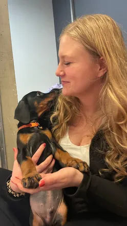 Girls practicing yoga in Leeds with playful Doberman puppies, enjoying a fun and cute puppy yoga class.