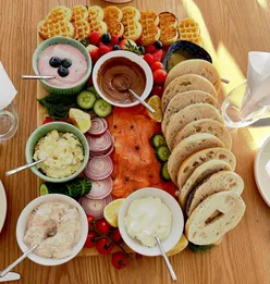 Colorful brunch board with bagels, fresh toppings, and vibrant food art, set for a cozy Sunday family gathering.