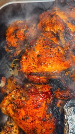 Delicious Caribbean street food featuring jerk chicken, grilled salmon, and reggae ribs with sides of rice and peas.