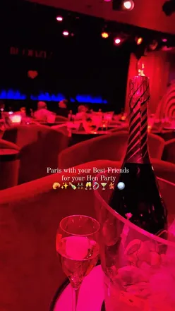 Group of friends celebrating a hen party in Paris, enjoying delicious food and drinks at a trendy restaurant.