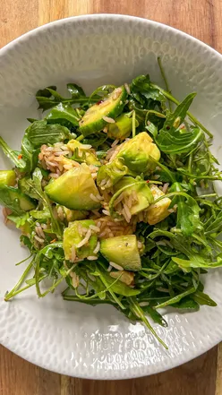 Crunchy rice salad with Tilda rice, avocado, cucumber, and rocket, drizzled with balsamic dressing.