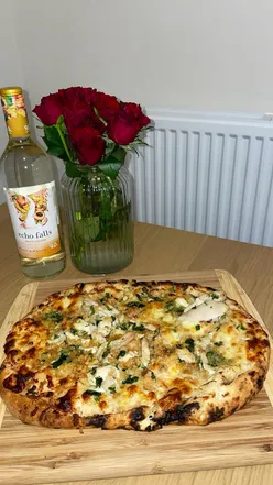 Limited edition M&S chicken kyiv and garlic butter pizza on a table, showcasing crispy crust and savory toppings.