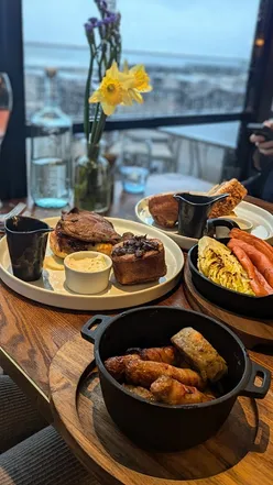Delicious Sunday roast with sea views at The White Horses, featuring cocktails and decadent desserts.