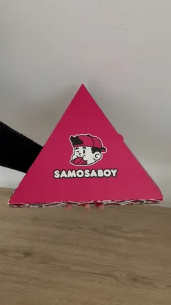 Box of unique samosas from Samosa Boy, featuring flavors like James Brownie and You're So Jammy, topped with chocolate and biscuits.