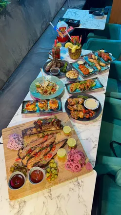 Delicious spread of halal dishes at Double Apple Kitchen, including lamb chops, tacos, and pina colada drinks.