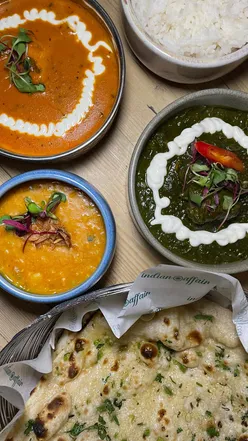 Delicious Indian feast featuring samosa chaat, butter chicken, garlic naan, and vibrant chutney tray.