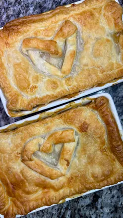 Delicious green chicken pie with vegetables, puff pastry, and herbs, freshly baked and golden brown.