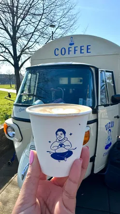 Girl enjoying a flat white from Titas Coffee, a female-run coffee truck in Bethnal Green, London.