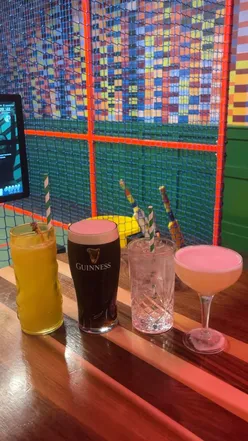 Enjoying cricket at Sixes London Bridge with delicious pizzas, burgers, and cocktails in a fun immersive setting.
