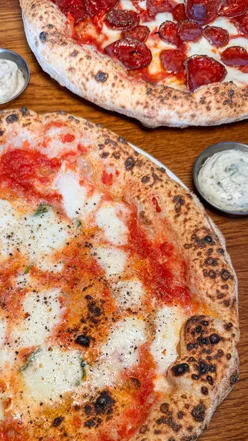 Delicious Provola e Pepe pizza with creamy mozzarella and black pepper at Pizza Pilgrims, Cardiff, on a sunny day.