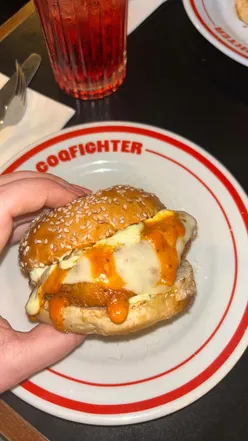 Spicy Chicken Parm burger with melted cheese and wings from Grasso x Coqfighter collaboration, a must-try dish.