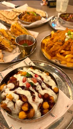 Delicious Indian street food at Karak Chaii: samosa chaat, bhel puri, masala chips, and refreshing Karak chai.