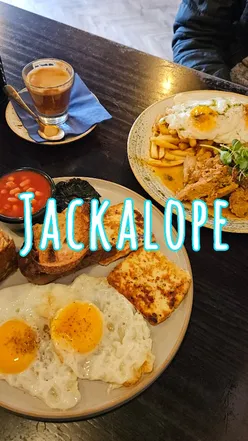 Cute bear latte art with brunch dishes, including veggie full English and pistachio cookie at Jackalope Cafe.