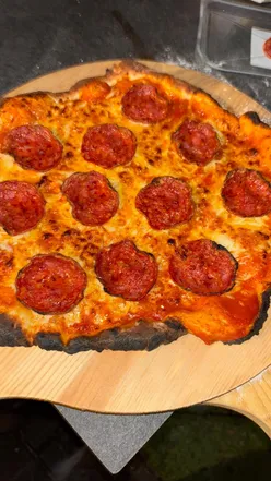 A delicious pizza with toppings at a lively pizza party, showcasing fun and celebration.
