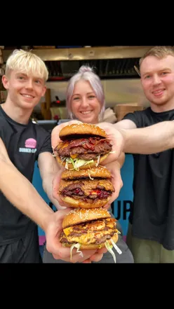 Delicious burgers on a table, promoting a contest for free burgers at BMU's new Stirchley restaurant.