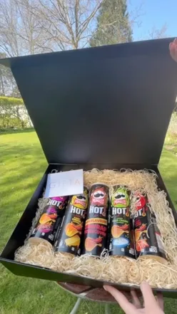 A large box of Pringles featuring new hot flavors, including Hot Blazinโ Fried Chicken and Sour Cream & Chive.