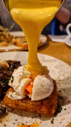 Delicious Sunday brunch featuring truffle hash browns, poached eggs, cacio e pepe beans, and banoffee waffles.