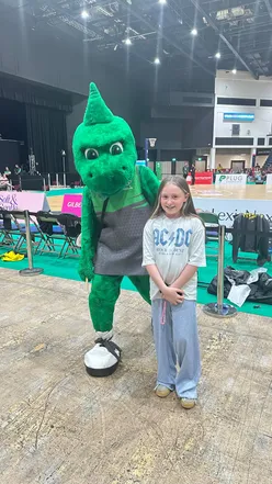 Isabella cheering at the Cardiff Dragons netball game, capturing family fun and excitement in the stands.
