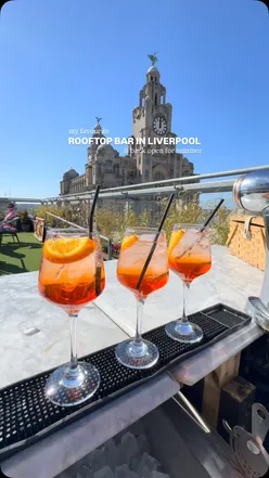 Enjoying a refreshing spritz at a rooftop bar in Liverpool on a sunny day, perfect for summer vibes.