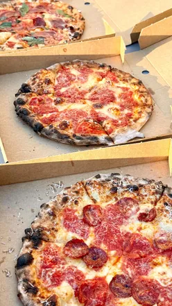 Delicious Margherita and Pepperoni pizzas with garlic and hot honey dips at Matchbox Pizza Co in Kingston Park.