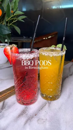 Delicious BBQ meal at BBQ Pods in Birmingham featuring a beef burger, crispy fries, and refreshing strawberry mojito.