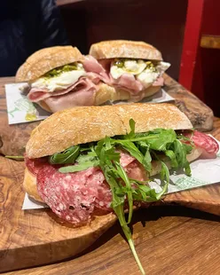 Authentic Italian deli sandwiches at Domus Italia in Manchester: Milano Panini with salame, parmigiano, and lettuce; Parma with ham, mozzarella, and tomato.