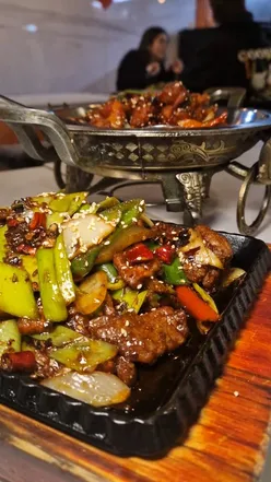 A table filled with large portions of Chinese dishes at a Newcastle restaurant, perfect for sharing.