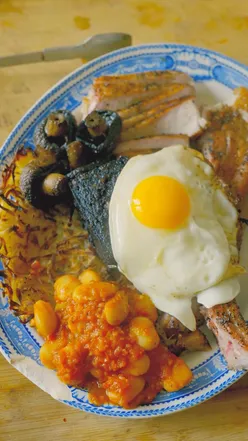 A delicious full English breakfast featuring smoked meat and tomahawk steak, perfect for a hearty meal.