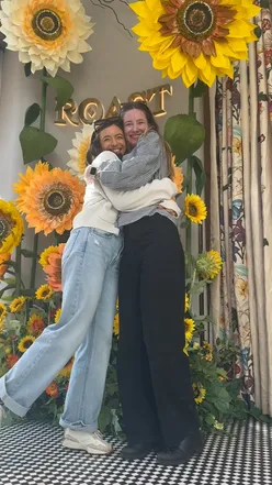 Two happy girls enjoying aesthetic afternoon tea with champagne, scotch egg, and sunflowers at Roast Restaurant, London.