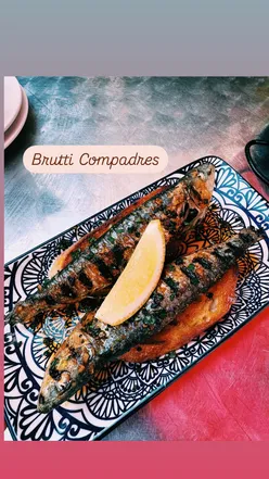Aperol spritz and grilled sardine on toast at a cozy Glasgow tapas bar, perfect for spring vibes.