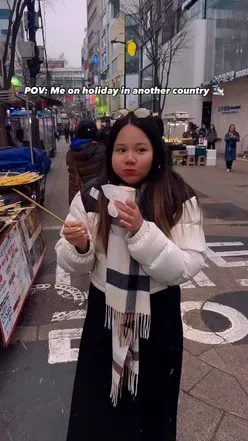 A traveler enjoying delicious Korean street food, showcasing vibrant dishes and a joyful expression.
