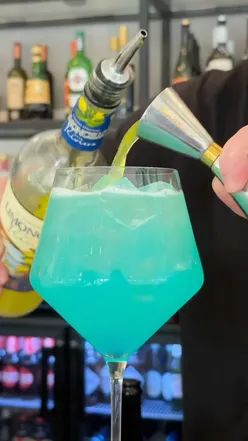Vibrant Sicilian Spritz cocktail with blue Curaรงao, lemon, and Prosecco, perfect for summer sipping.