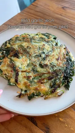 Crispy wild garlic jeon pancakes served with a soy dipping sauce, showcasing Korean cuisine's vibrant flavors.