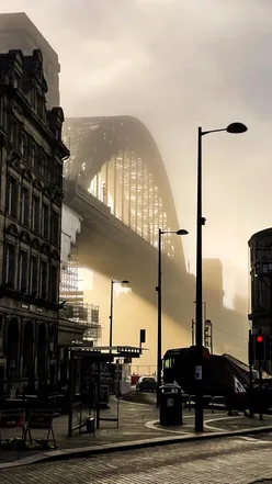 Foggy Newcastle Quayside with the Tyne Bridge, showcasing the city's iconic skyline and serene morning atmosphere.