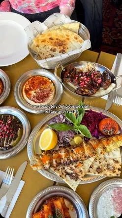 Delicious mezze spread at Baba's Mezzebath, showcasing vibrant dishes and drinks in a cozy setting.