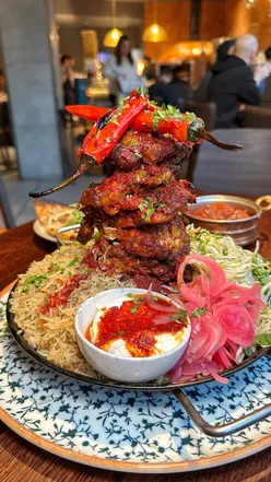 Colorful sharing shawarma platter with mezze, rice, and dips at Gallio's Mediterranean Bottomless Feast.