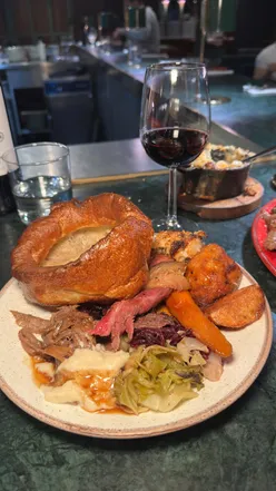 A mouthwatering Sunday roast featuring smoked lamb, aged beef, and roast pork with honey glazed carrots at Temper Restaurant.