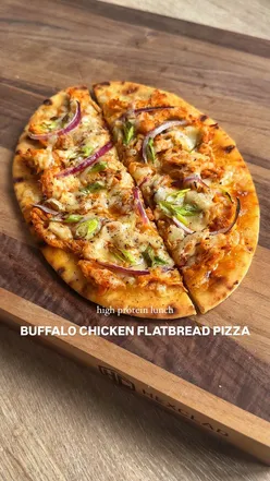 Buffalo chicken flatbread pizza topped with cheese, red onion, and spring onion, ready to enjoy for lunch.
