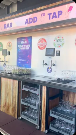 Self pour bar at Gravity Max Liverpool, featuring outdoor terrace and patrons enjoying pints in the sunshine.