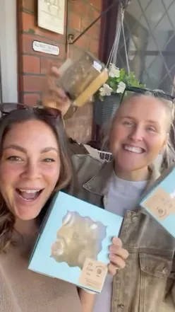 Two friends enjoying delicious cinnamon rolls and Easter treats at a charming cupboard in Southport.