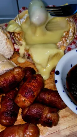 Pigs in blankets with gooey Camembert, crusty bread, and caramelised onion chutney for a perfect bank holiday meal.