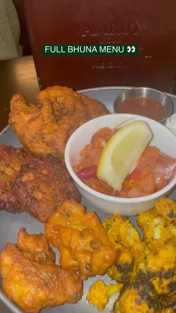 Delicious Full Bhuna menu at Chaakoo, featuring curries, naan, and a sharing platter of pakora.