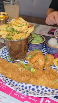 Delicious fish and chips with battered fish, prawns, and mushy peas at a popular Glasgow chippy.