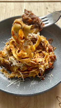Delicious slow cooked shredded beef ragu served with tagliatelle, garnished with parsley and Parmesan cheese.