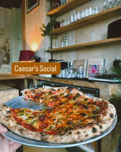 Hearty pizzas at @caesars.social in Glasgow, featuring margherita and specials with pepperoni crumbs, in a relaxed, minimalistic diner vibe.