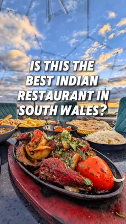 Cozy dining pod at 1988 Indian restaurant in South Wales, featuring vibrant Indian dishes and ocean views.