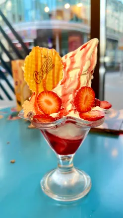 Indulgent desserts at Creams Nottingham: sundaes, waffles, and shakes, featuring fresh strawberries and chocolate cake.