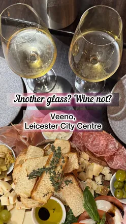 Wine tasting at Veeno with Grillo DOC, charcuterie board, and friendly staff in a lively restaurant setting.
