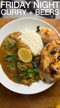Delicious butter chicken curry with garlic naan and beers, perfect for a Friday night feast with friends.
