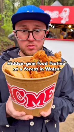 Street food festival in a Welsh forest with fire pits, lights, and delicious food amidst a vibrant atmosphere.